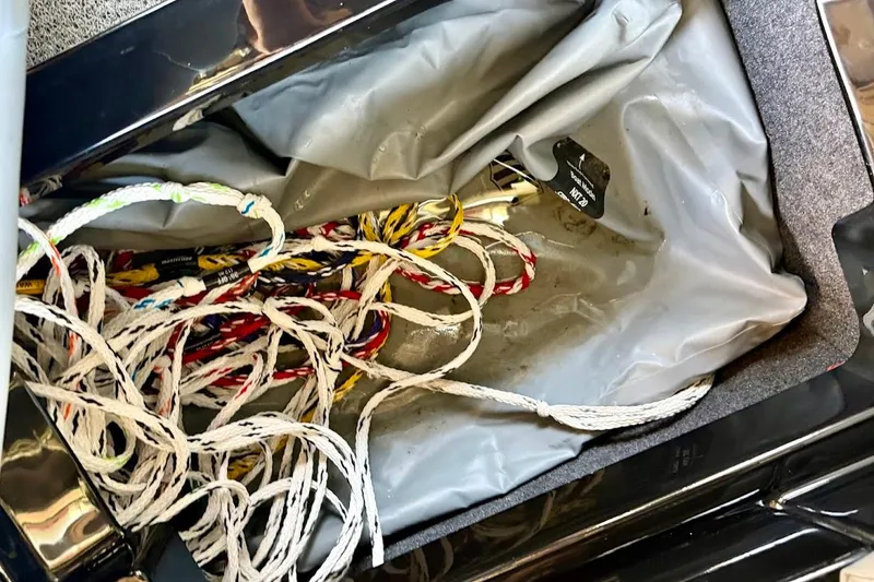 Slide: The Image of Tangled ropes in a 2023 MasterCraft NXT20 storage compartment. - 37