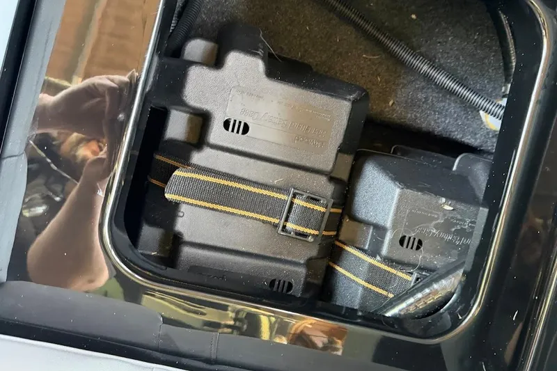 Slide: The Image of Battery compartment of a 2023 MasterCraft NXT20 boat with secured black casing. - 39