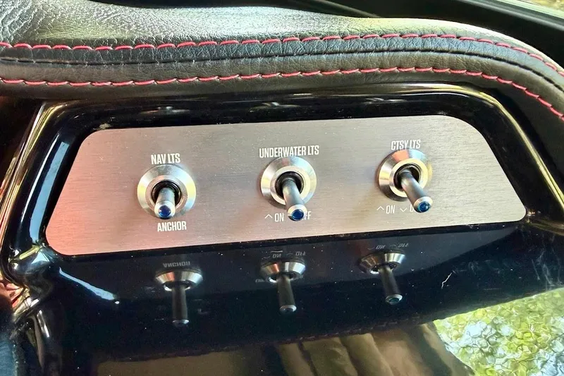 Slide: The Image of 2023 MasterCraft NXT20 boat control panel with switches for navigation, underwater, and courtesy lights. - 48