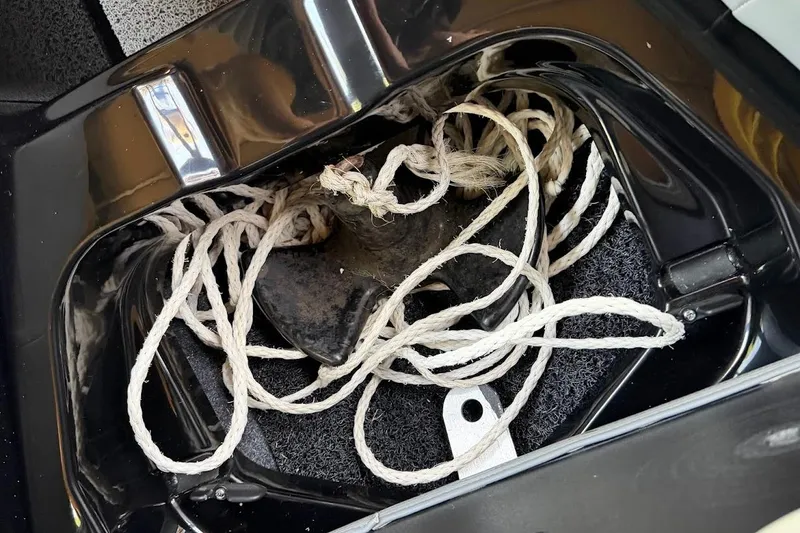 Slide: The Image of Anchor and rope stored in a 2023 MasterCraft NXT20 boat compartment. - 54