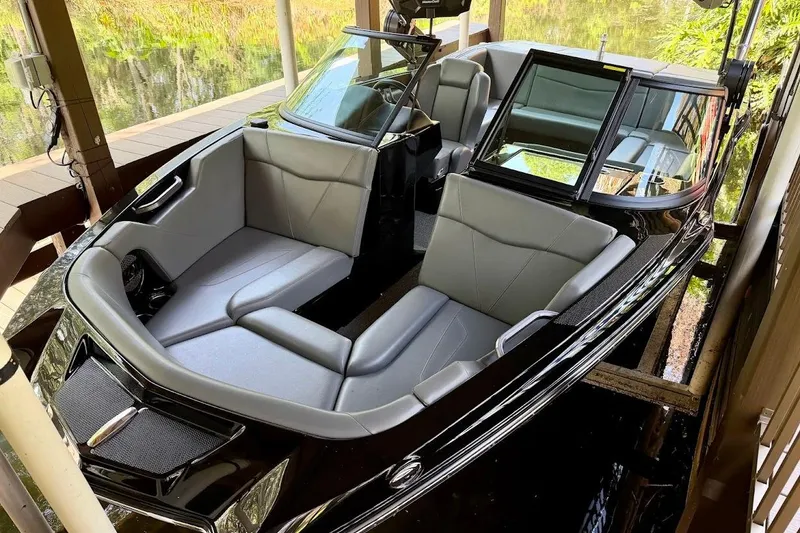 Slide: The Image of 2023 MasterCraft NXT20 boat with sleek gray seating and modern design in a dock setting. - 7
