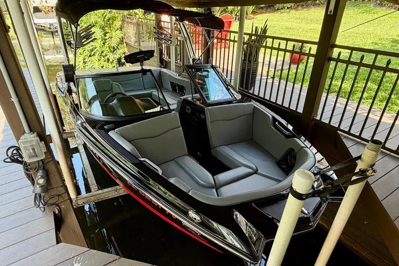 Slide: The Image of 2023 MasterCraft NXT20 boat docked under a covered area, featuring sleek design and modern seating. - 8