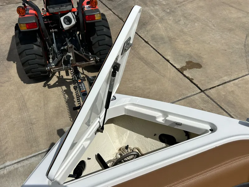 Slide: The Image of 2022 Cobalt R4 Outboard with open storage compartment and tractor in background. - 15