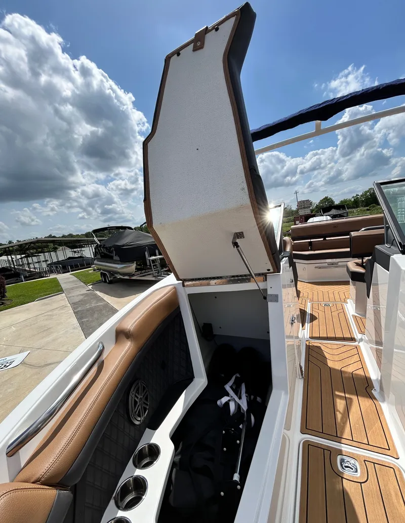 Slide: The Image of 2022 Cobalt R4 Outboard with open storage compartment and sunny sky. - 19