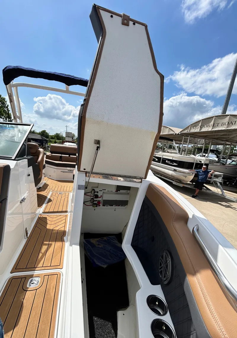 Slide: The Image of 2022 Cobalt R4 Outboard boat with open storage compartment lid. - 21