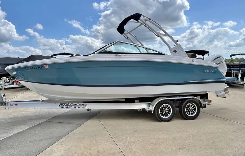Slide: The Image of 2022 Cobalt R4 Outboard boat on trailer under blue sky. - 4