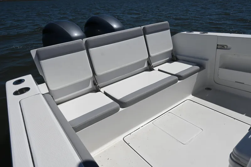 Slide: The Image of 2022 Release 240 RX boat with cushioned seating, dual engines, and cup holders on a sunny day. - 24