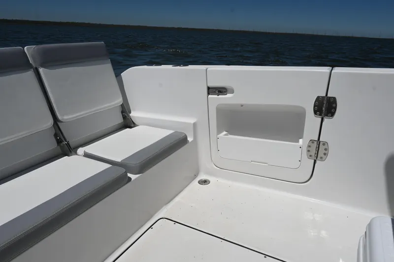 Slide: The Image of 2022 Release 240 RX boat interior with cushioned seating and storage compartment. - 27