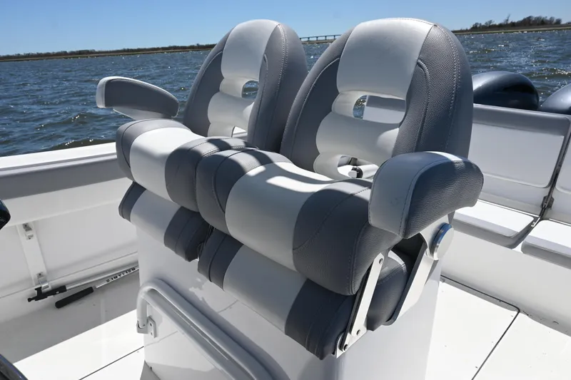 Slide: The Image of Dual captain's chairs on 2022 Release 240 RX boat, overlooking calm waters. - 31