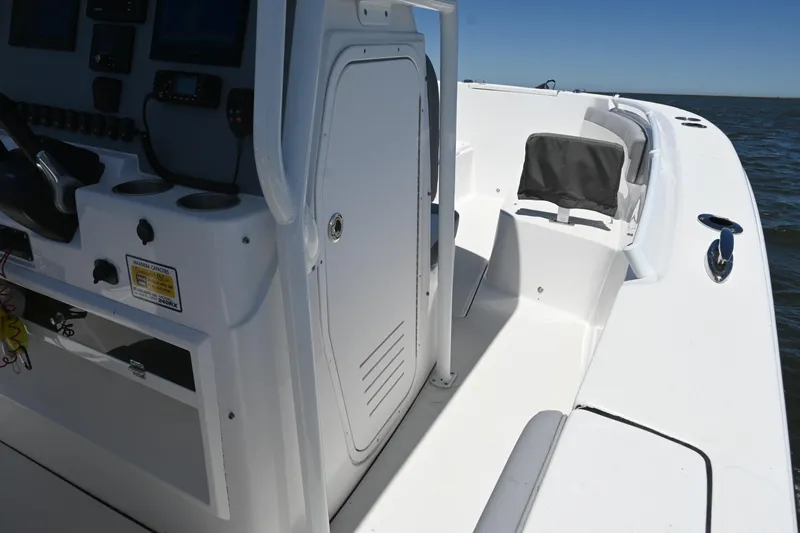 Slide: The Image of 2022 Release 240 RX boat interior with steering console and seating, on open water. - 34