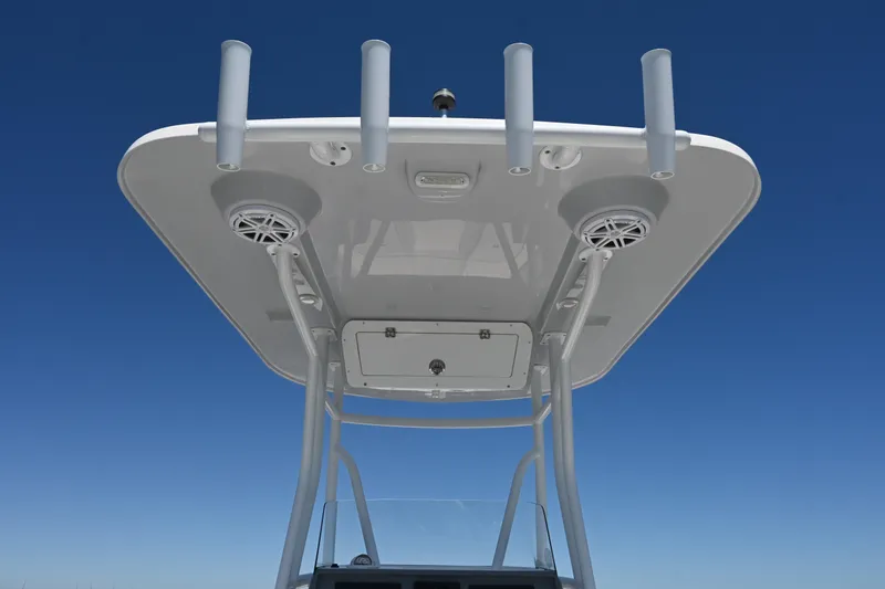 Slide: The Image of 2022 Release 240 RX boat's T-top with rod holders and speakers against clear blue sky. - 35