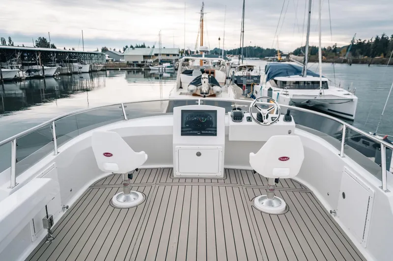 Slide: The Image of 2024 Lindell 46 boat helm with dual seats, docked in a marina. - 19