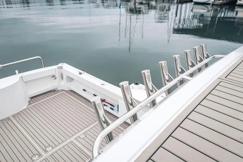 Slide: The Image of Sleek 2024 Lindell 46 yacht deck with polished metal railings and calm marina waters. - 26