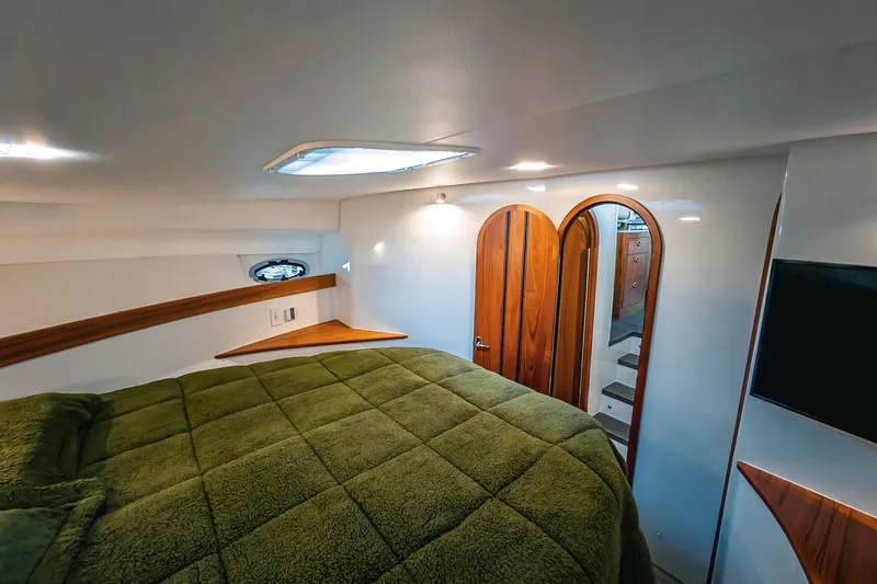 Slide: The Image of Luxurious cabin interior of 2024 Lindell 46 yacht with green bedding and wooden accents. - 38