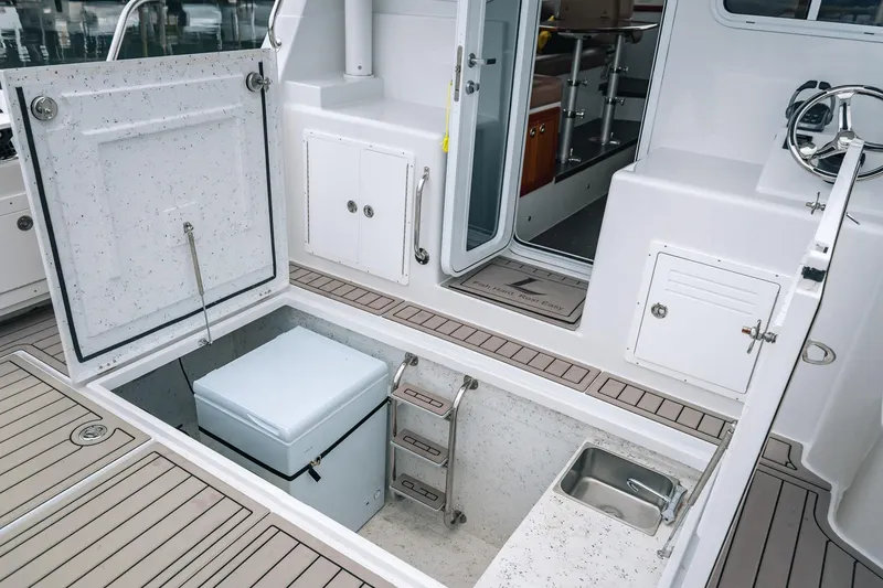 Slide: The Image of 2024 Lindell 46 boat interior with open storage, ladder, and sink. - 4