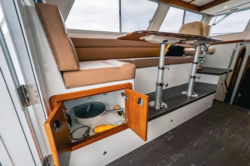 Slide: The Image of 2024 Lindell 46 interior with seating, table, and storage compartment open. - 52