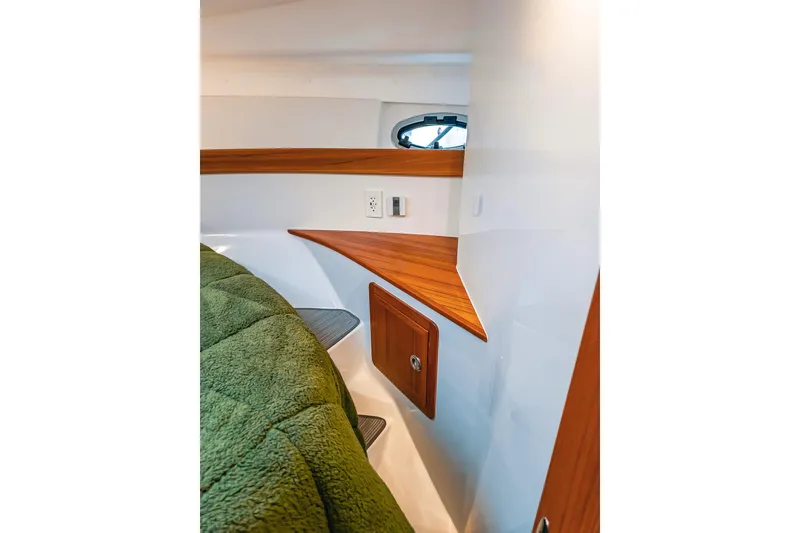 Slide: The Image of Interior of 2024 Lindell 46 boat with wood accents and green bedding. - 54