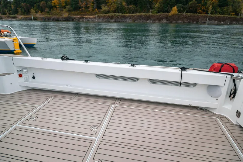 Slide: The Image of 2024 Lindell 46 boat deck with sleek design, overlooking calm waters and lush shoreline. - 68