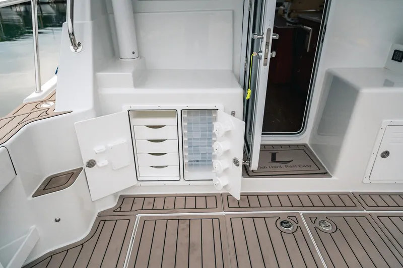Slide: The Image of 2024 Lindell 46 boat interior with open storage compartments and teak flooring. - 69