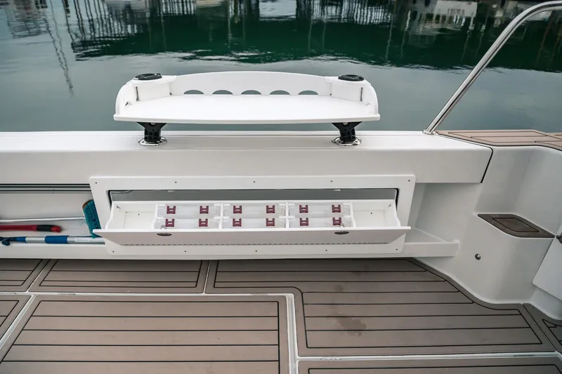Slide: The Image of 2024 Lindell 46 boat deck with storage compartments and fishing rod holders. - 70