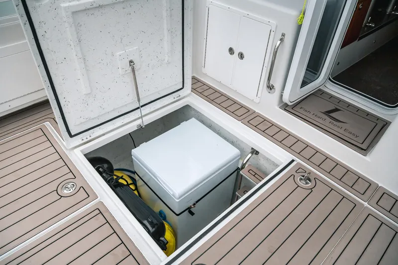 Slide: The Image of Open storage compartment on 2024 Lindell 46 boat deck, revealing equipment inside. - 71