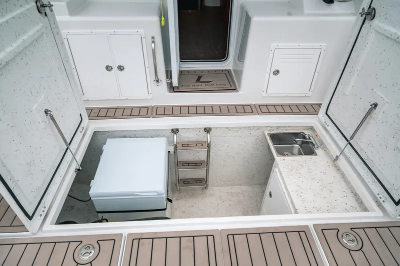 Slide: The Image of 2024 Lindell 46 boat interior with storage, sink, and access hatch. - 72