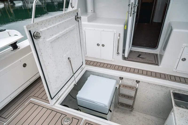 Slide: The Image of 2024 Lindell 46 boat deck with open hatch, storage, and ladder access. - 73