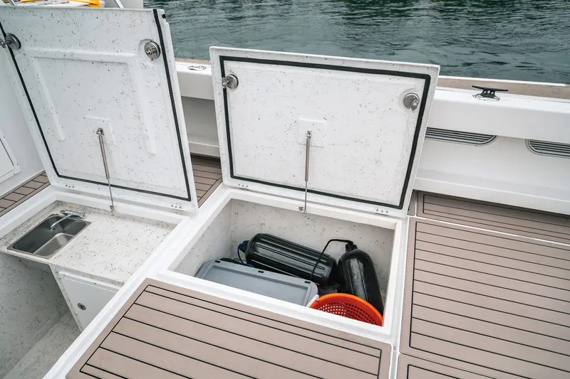 Slide: The Image of Open storage compartments on a 2024 Lindell 46 boat deck with visible equipment. - 74