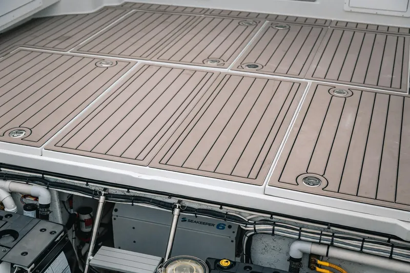 Slide: The Image of 2024 Lindell 46 boat deck with Seakeeper system, featuring sleek, modern design and storage compartments. - 78