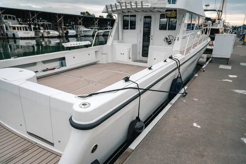 Slide: The Image of 2024 Lindell 46 boat docked at marina, showcasing sleek design and spacious deck. - 82