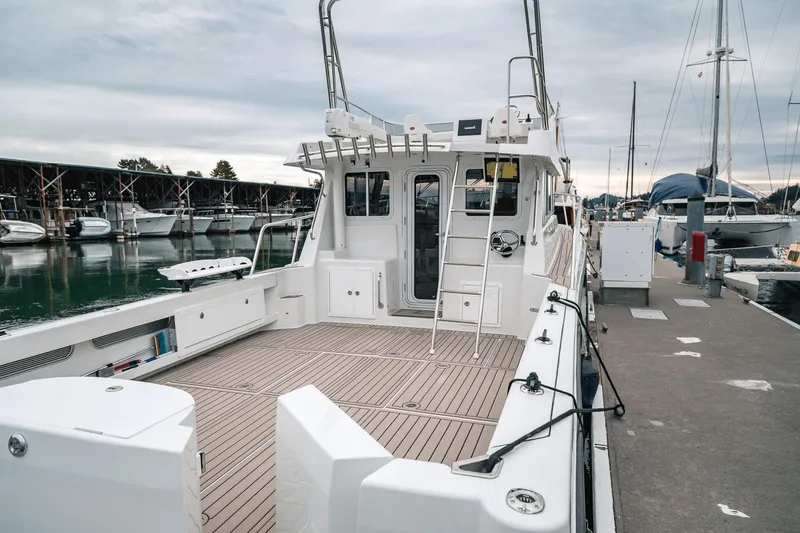 Slide: The Image of 2024 Lindell 46 boat docked at marina, showcasing spacious deck and modern design. - 88