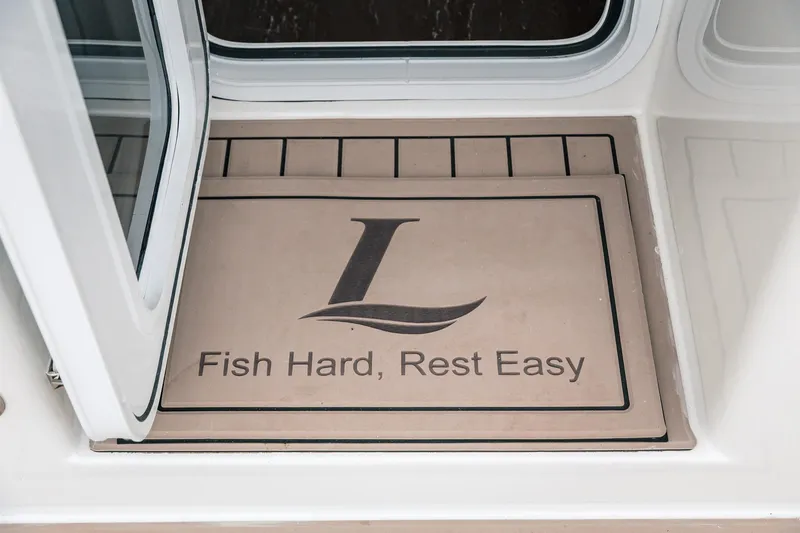 Slide: The Image of Doormat on Lindell 46 boat, 2024 model, with "Fish Hard, Rest Easy" slogan. - 89