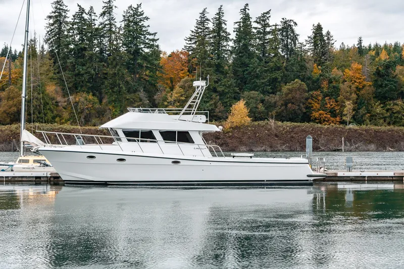 Slide: The Image of 2024 Lindell 46 yacht docked by autumn trees, reflecting on calm water. - 91