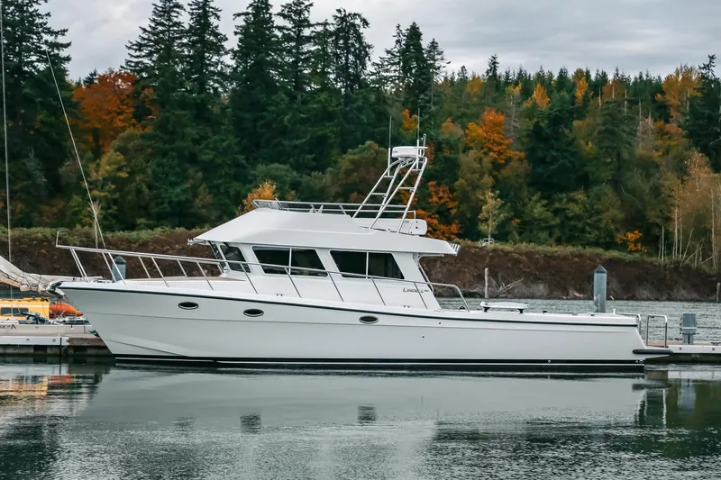 Slide: The Image of 2024 Lindell 46 yacht docked by autumn forest shoreline. - 95