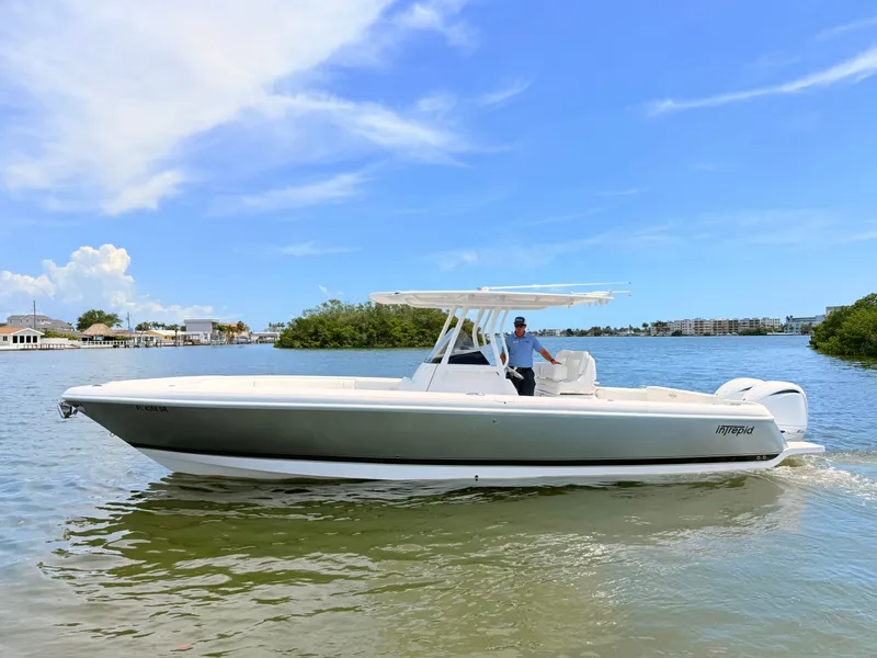 Slide: The Image of 2020 Intrepid 327CC boat on calm water under sunny skies. - 15