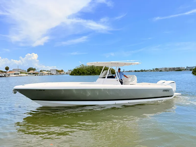 Slide: The Image of 2020 Intrepid 327CC boat on calm water under clear sky. - 16