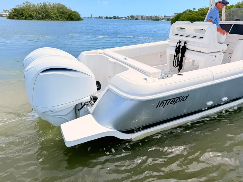 Slide: The Image of 2020 Intrepid 327CC boat on calm water with outboard engines. - 24