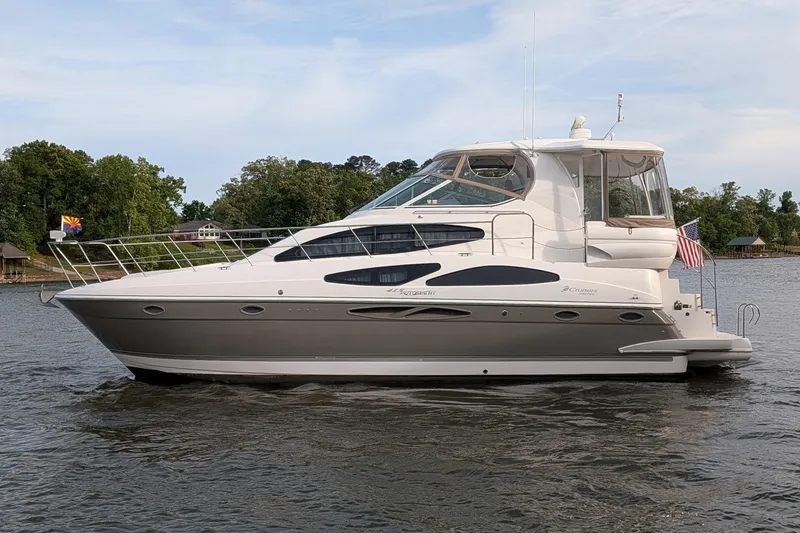 The Image of 2008 Cruisers Yachts 415 Express Motoryacht on a serene lake with lush greenery. - 0