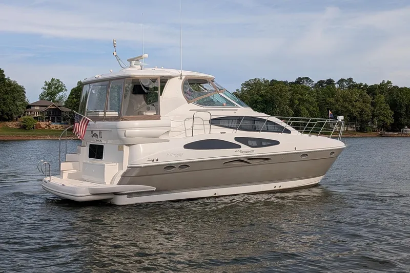 Slide: The Image of 2008 Cruisers Yachts 415 Express Motoryacht on a serene lake with lush greenery. - 1
