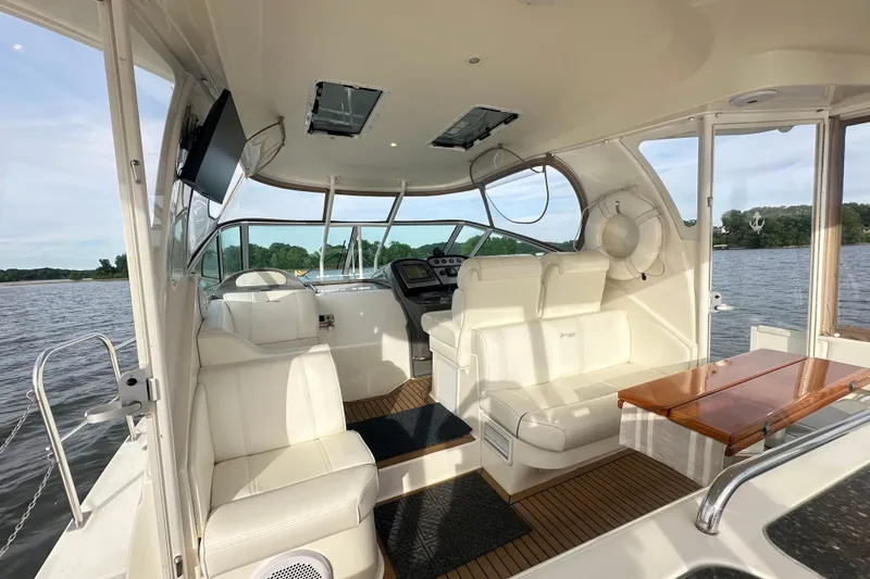 Slide: The Image of 2008 Cruisers Yachts 415 Express Motoryacht interior with white seating and wooden table. - 10