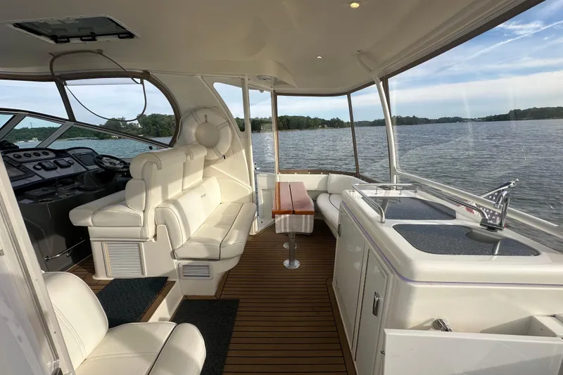 Slide: The Image of 2008 Cruisers Yachts 415 Express Motoryacht interior with seating, table, and kitchenette by the water. - 11