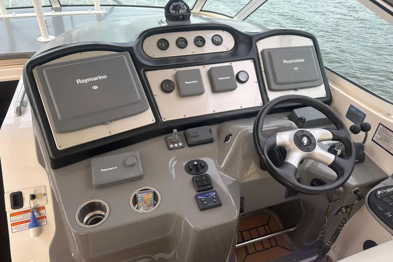 Slide: The Image of 2008 Cruisers Yachts 415 Express Motoryacht helm with Raymarine navigation systems and steering wheel. - 19