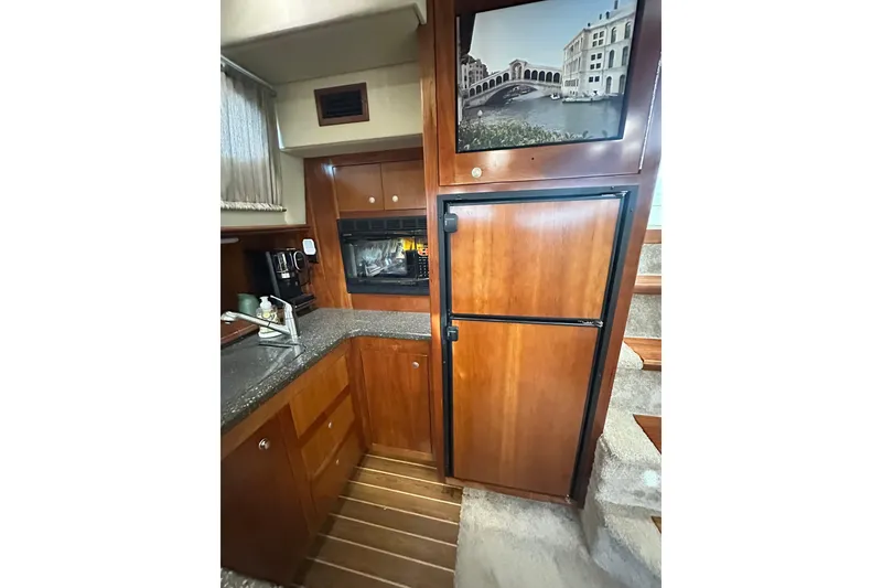 Slide: The Image of 2008 Cruisers Yachts 415 Express Motoryacht kitchen with wood cabinetry and appliances. - 29
