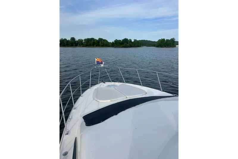 Slide: The Image of 2008 Cruisers Yachts 415 Express Motoryacht on serene lake with lush green shoreline. - 4