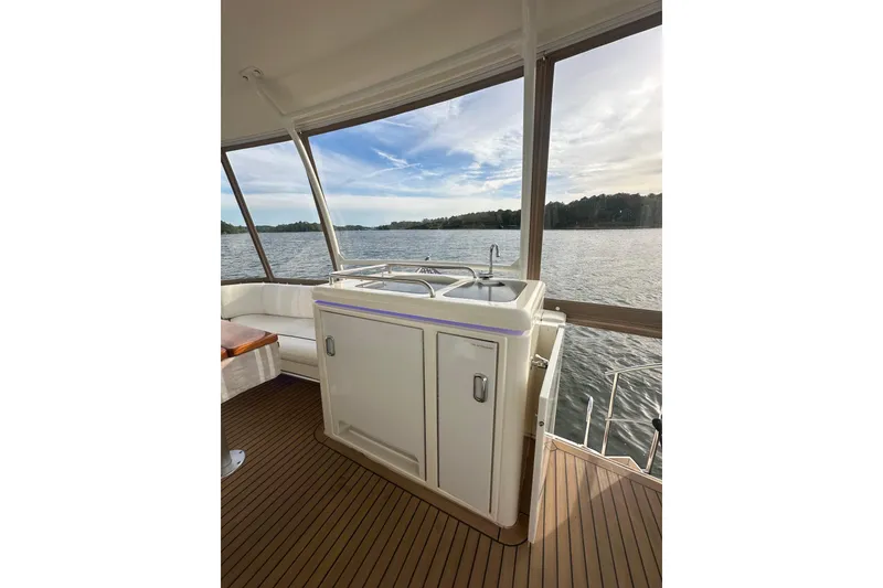 Slide: The Image of 2008 Cruisers Yachts 415 Express Motoryacht interior with sink, overlooking serene water view. - 9