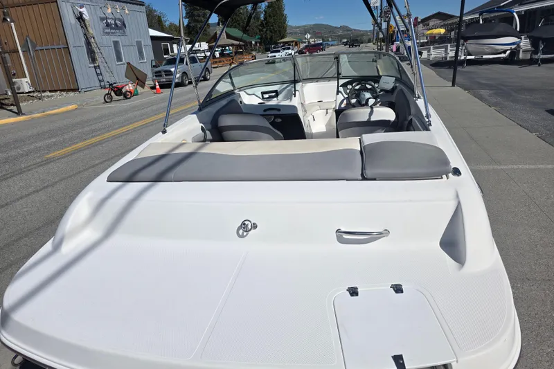 Slide: The Image of 2014 Reinell 207 LS boat parked on a street, showcasing sleek design and spacious seating. - 4