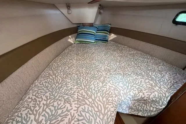 Slide: The Image of 2023 Ranger Tugs R-27 cabin with cozy bed and decorative pillows. - 15
