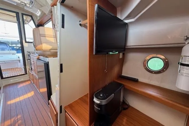 Slide: The Image of Interior of 2023 Ranger Tugs R-27 boat with TV, porthole, and wooden cabinetry. - 16