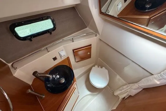 Slide: The Image of Compact bathroom in 2023 Ranger Tugs R-27 boat with sink, toilet, and mirror. - 17