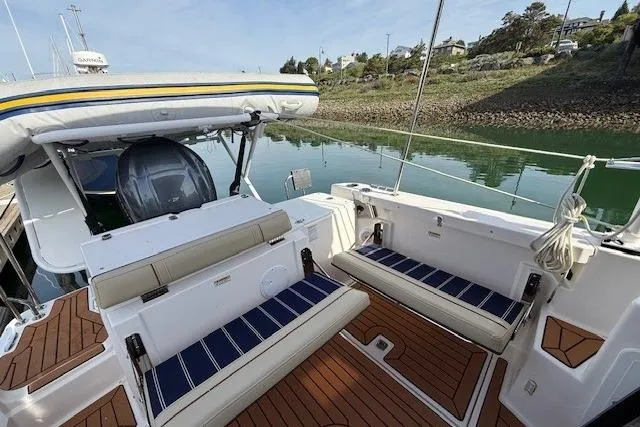 Slide: The Image of 2023 Ranger Tugs R-27 boat with spacious deck and seating, docked by calm waters. - 18